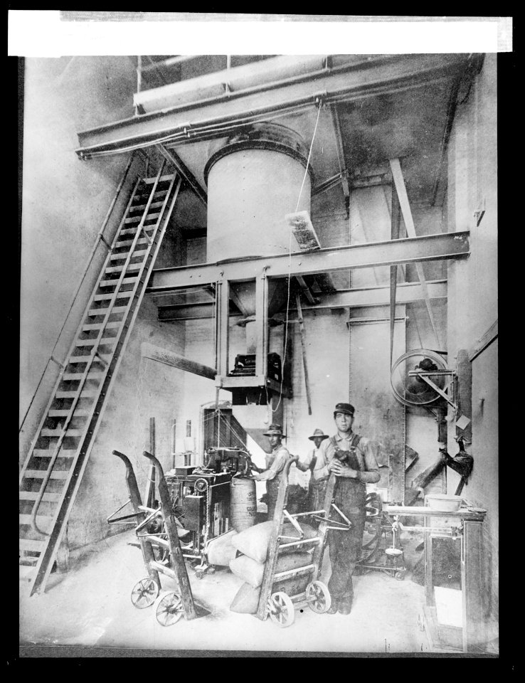 Filling, weighing, and sewing sacks of granulated sugar in a beet sugar factory LCCN2016824497