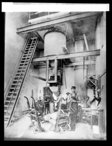 Filling, weighing, and sewing sacks of granulated sugar in a beet sugar factory LCCN2016824497