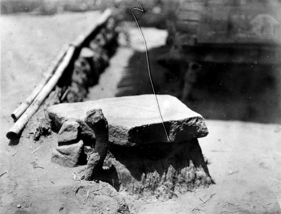 Flat sten med grund ringfåra. Stenarna framför föreställa man och kvinna. Kantewoe. Indonesien - SMVK - 010718