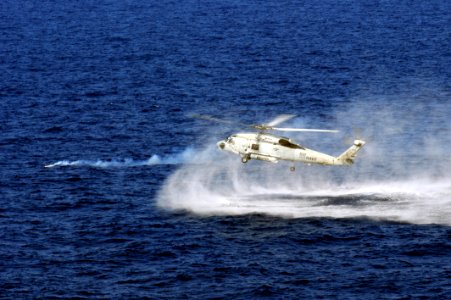 Flickr - Official U.S. Navy Imagery - A helicopter hovers near a smoke ring during a training drill.