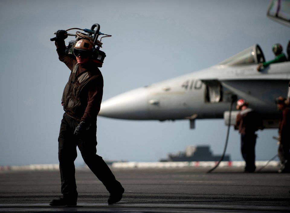 Flickr - Official U.S. Navy Imagery - A Sailor carries a hydraulic servicing unit on the flight deck.