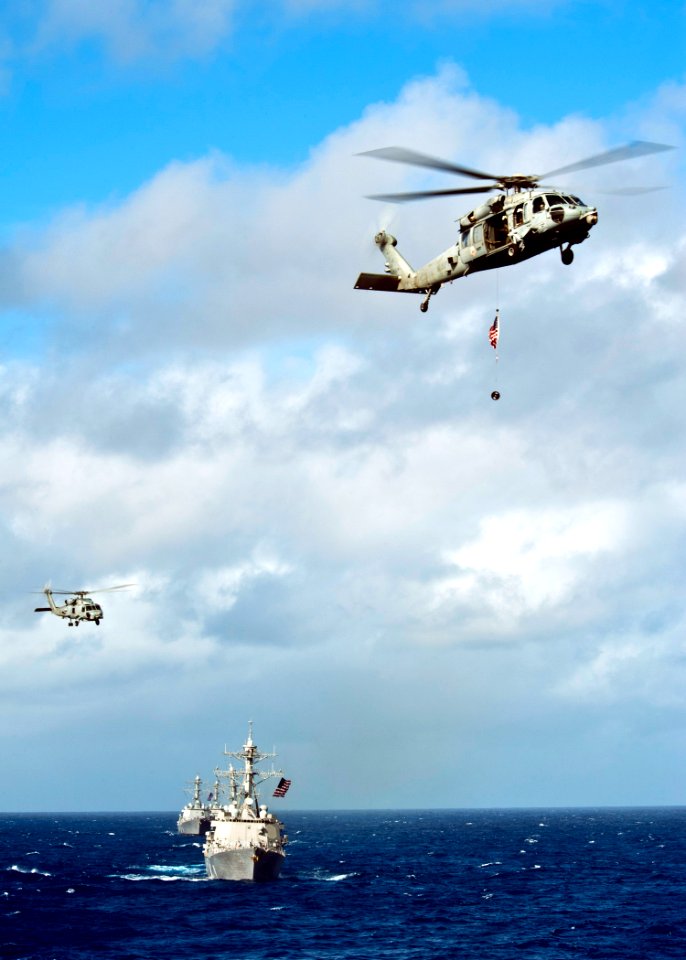 Flickr - Official U.S. Navy Imagery - A helicopter carries an American flag during an air power demonstration for participants of a tiger cruise.