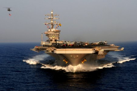 Flickr - Official U.S. Navy Imagery - A helicopter flies the national ensign alongside USS Dwight D. Eisenhower. (1)