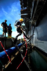 Flickr - Official U.S. Navy Imagery - A Navy diver jumps into the water to perform underwater hull maintenance.