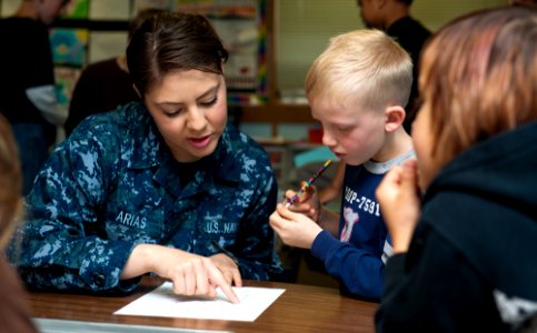Flickr - Official U.S. Navy Imagery - A Sailor assists a student with his classwork during a community relations project at Jackson Park Elementary School.