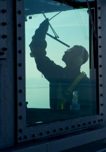 Flickr - Official U.S. Navy Imagery - A Sailor cleans the widows on the bridge.