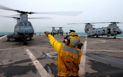 Flickr - Official U.S. Navy Imagery - A Sailor signals a helicopter to turn off its engine on the flight deck. photo