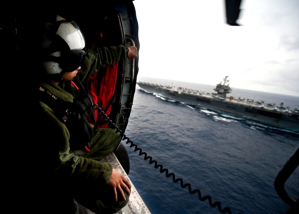Flickr - Official U.S. Navy Imagery - A Sailor looks out from a helicopter at USS Enterprise.