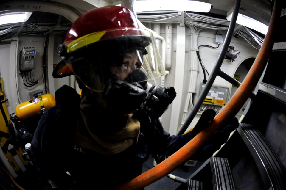 Flickr - Official U.S. Navy Imagery - A Sailor passes a fire hose to Sailors fighting a simulated fire during a damage control drill.
