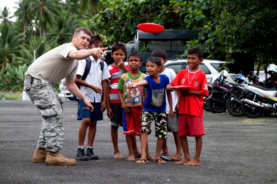 Flickr - Official U.S. Navy Imagery - An Army Spc. teaches a group of local children to properly throw a Frisbee during a civic action project.