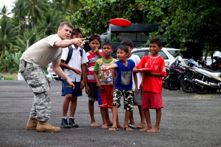 Flickr - Official U.S. Navy Imagery - An Army Spc. teaches a group of local children to properly throw a Frisbee during a civic action project.