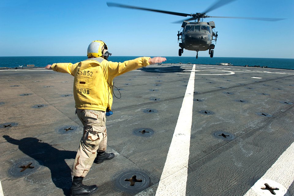 Flickr - Official U.S. Navy Imagery - A Sailor signals a helicopter to land.