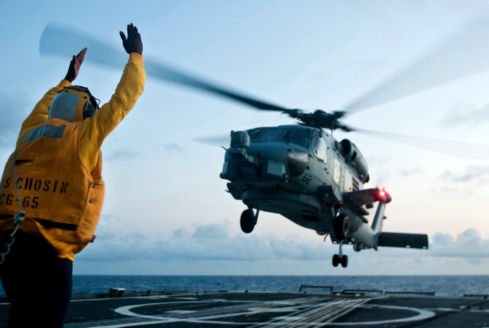 Flickr - Official U.S. Navy Imagery - A Sailor signals lift off to a helicopter.