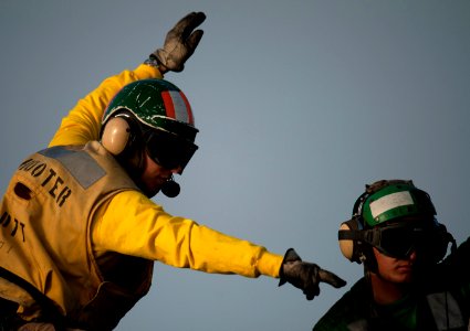 Flickr - Official U.S. Navy Imagery - A Sailor signals while launching aircraft from the waist catapults on the flight deck. (1)
