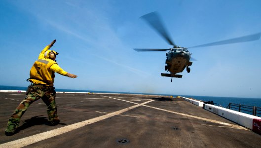 Flickr - Official U.S. Navy Imagery - A Sailor signals a helicopter to land on the deck.