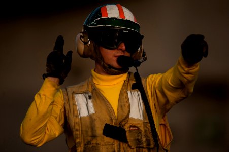 Flickr - Official U.S. Navy Imagery - A Sailor signals while launching aircraft from the waist catapults on the flight deck.