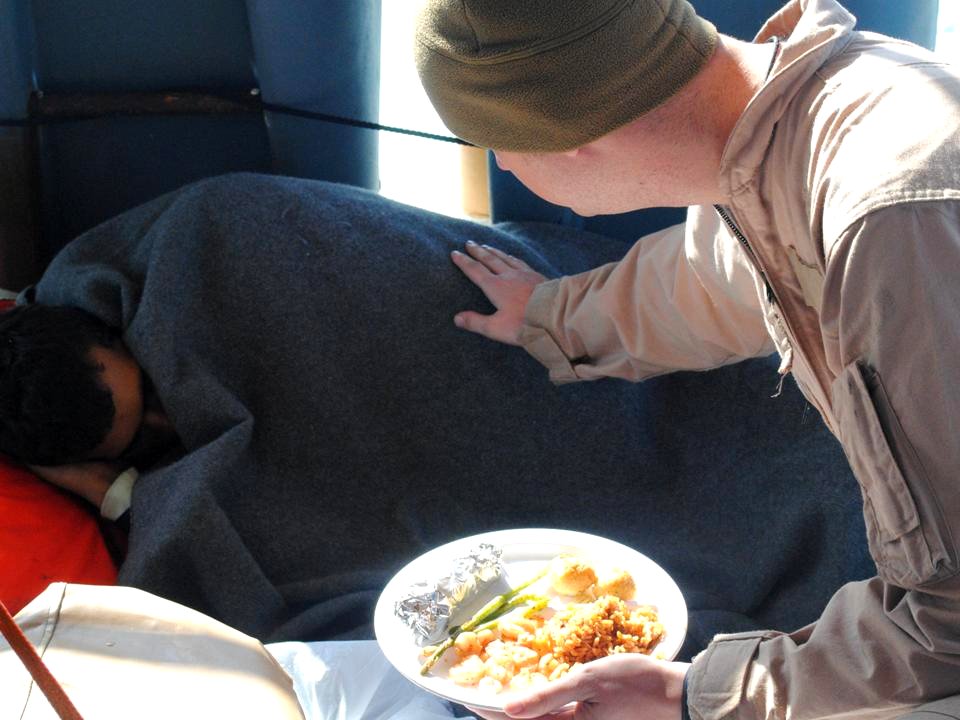 Flickr - Official U.S. Navy Imagery - A U.S. Coast Guardsman offers food to an Iranian mariner.