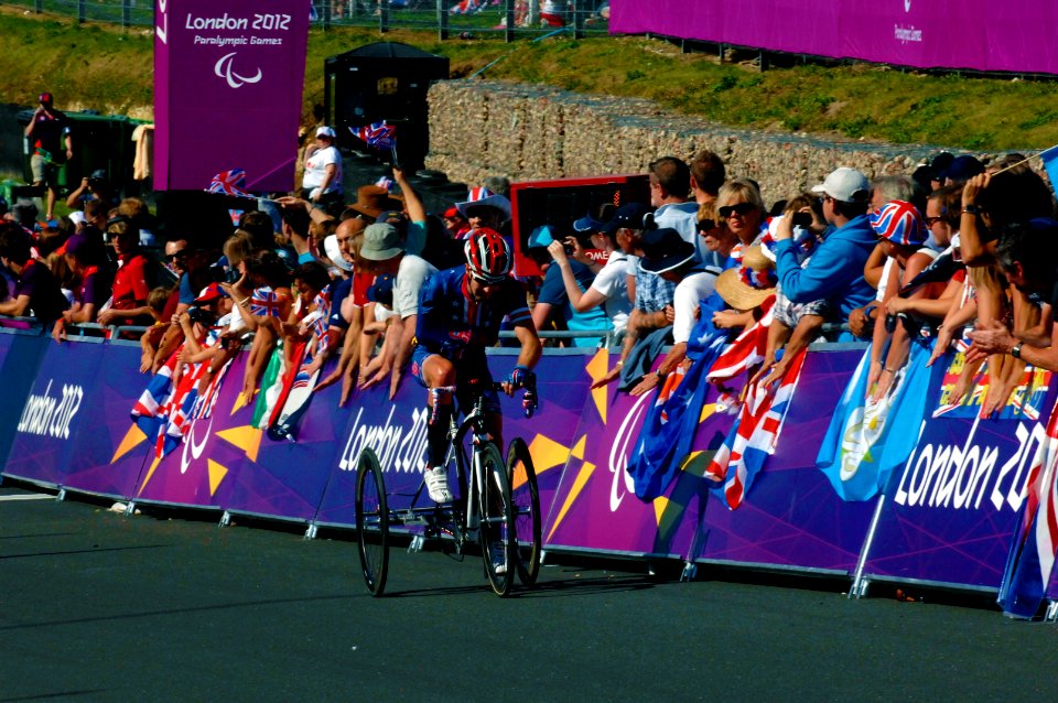 Flickr - Official U.S. Navy Imagery - A U.S. Navy veteran and 2012 U.S. Paralympic road cyclist rides past fans.