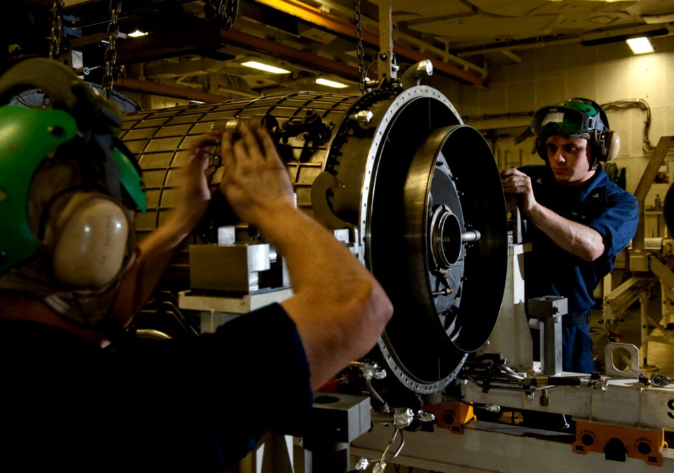 Flickr - Official U.S. Navy Imagery - Airman Travis Baldridge and Aviation Machinist's Mate 3rd Class Ryan Thomas secure a compressor module for an F404 turbofan.