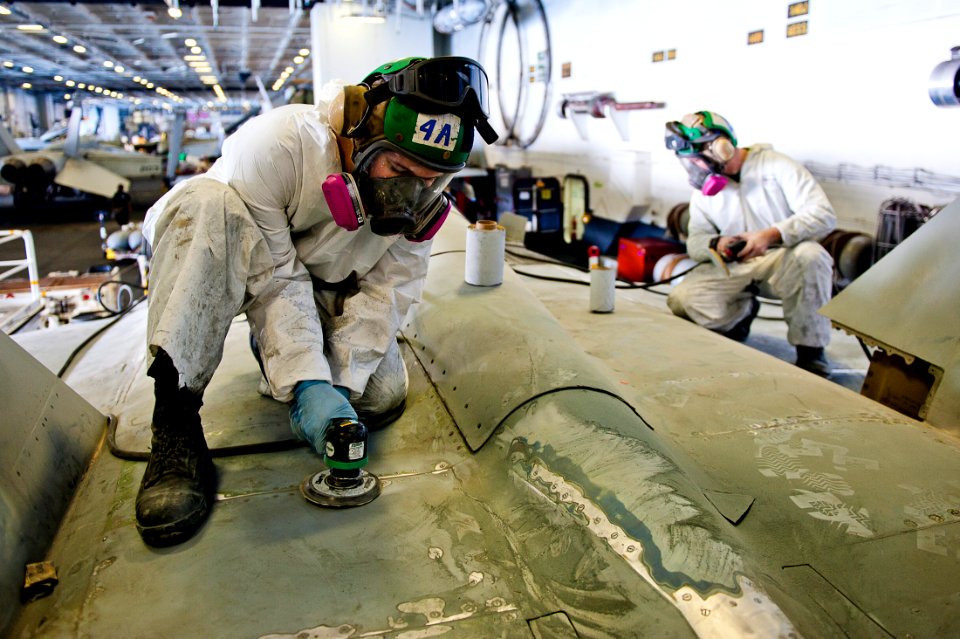 Flickr - Official U.S. Navy Imagery - Aviation Structural Mechanic Airman Albert Marsh sands an F-A-18C Hornet.
