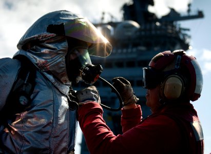 Flickr - Official U.S. Navy Imagery - Crash and salvage personnel help one another don hot suits before entering a simulated aircraft fire