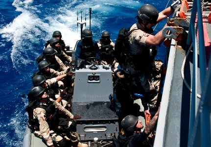 Flickr - Official U.S. Navy Imagery - Ens. Steven McClendon climbs down the side of USS Chosin.