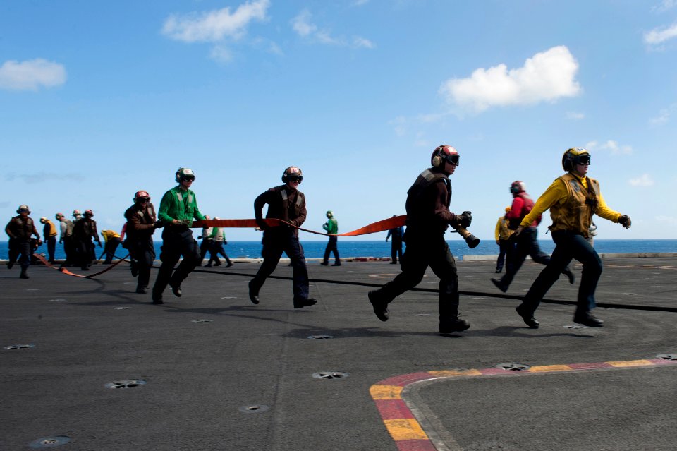 Flickr - Official U.S. Navy Imagery - Flight deck personnel haul out hoses to combat a simulated aircraft fire