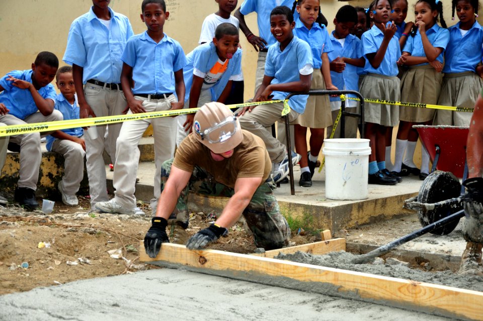Flickr - Official U.S. Navy Imagery - Navy Seabee smoothes and levels wet cement.