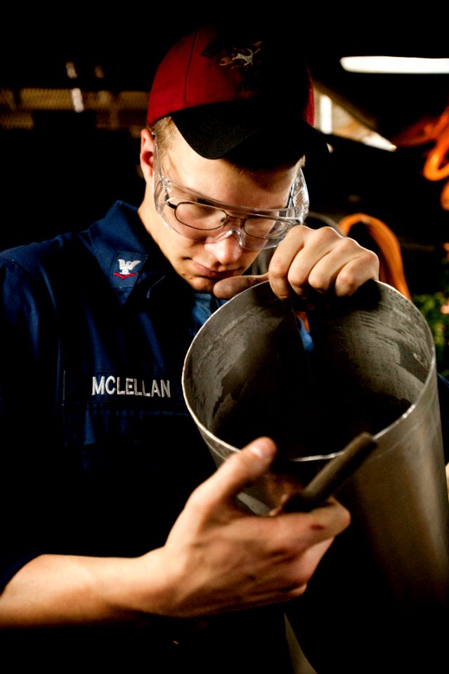 Flickr - Official U.S. Navy Imagery - New Hampshire Sailor inspects a freshly cut piece of sheet metal for burrs.