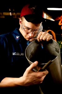 Flickr - Official U.S. Navy Imagery - New Hampshire Sailor inspects a freshly cut piece of sheet metal for burrs.