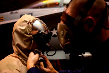 Flickr - Official U.S. Navy Imagery - Sailor helps another with protective garment.