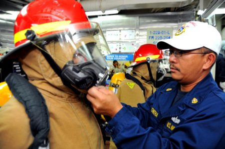 Flickr - Official U.S. Navy Imagery - Sailor helps with firefighting gear.