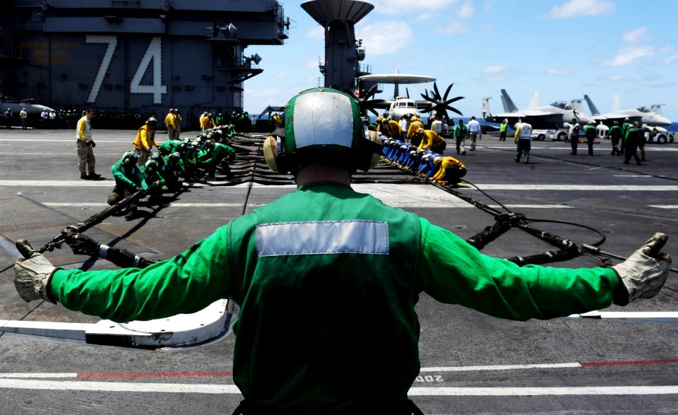 Flickr - Official U.S. Navy Imagery - Sailor signals for his shipmates to set up the barricade during flight deck drills aboard USS John C. Stennis