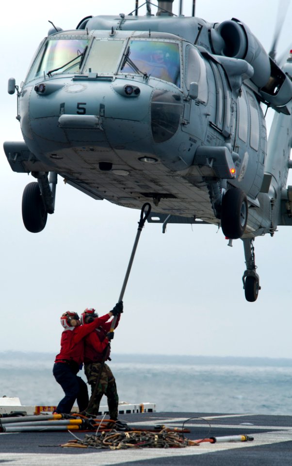 Flickr - Official U.S. Navy Imagery - Sailors attach cargo nets to a helicopter.