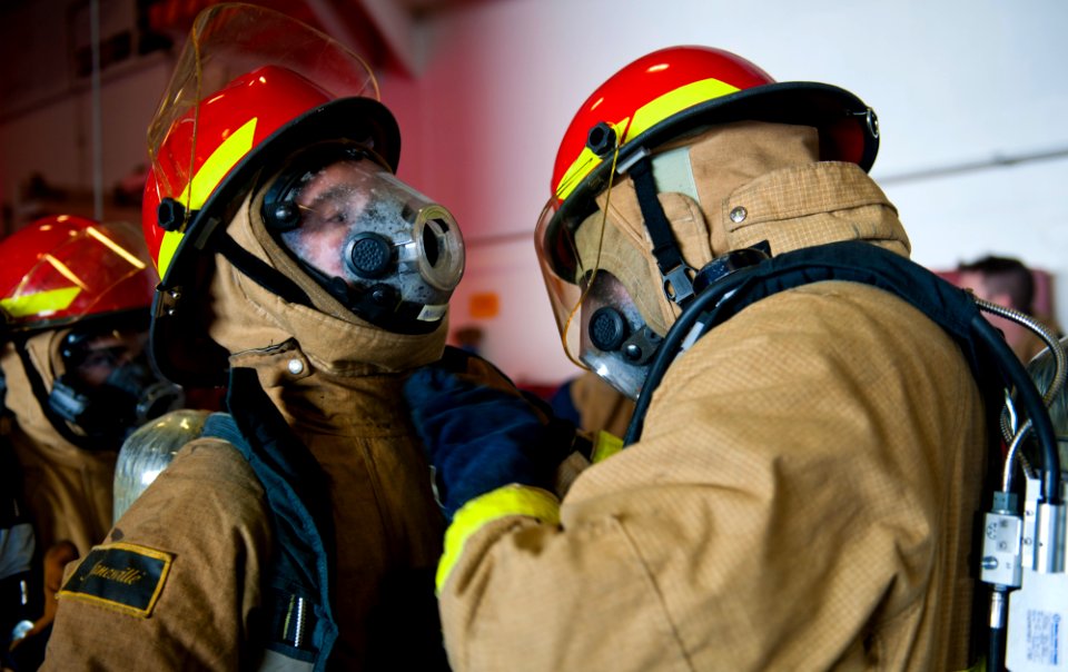 Flickr - Official U.S. Navy Imagery - Sailors from the flying squad help each other don fire fighting equipment.