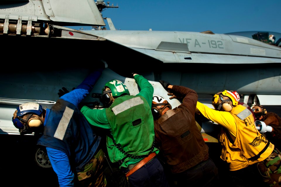 Flickr - Official U.S. Navy Imagery - Sailors push an F-A-18C Hornet in position.