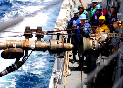 Flickr - Official U.S. Navy Imagery - Sailors guide in a fuel hose during a replenishment-at-sea.