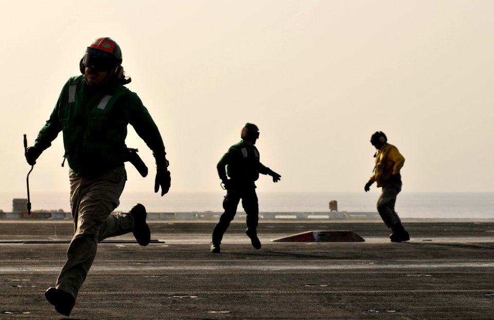 Flickr - Official U.S. Navy Imagery - Sailors run to clear the landing area after securing the waist catapults.