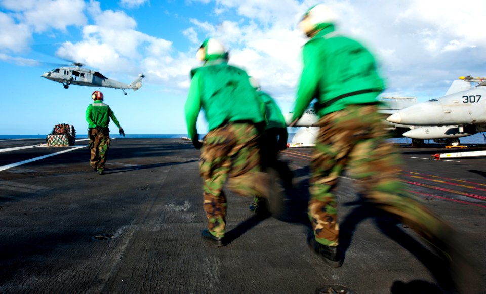 Flickr - Official U.S. Navy Imagery - Sailors run to move cargo on the flight deck during a vertical replenishment aboard the Nimitz-class aircraft carrier USS John C. Stennis.