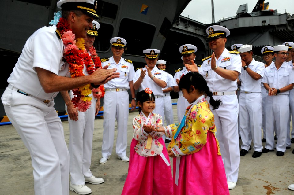 Flickr - Official U.S. Navy Imagery - The CO of USS George Washington presents coins to children dressed in traditional Korean costume at a welcome ceremony