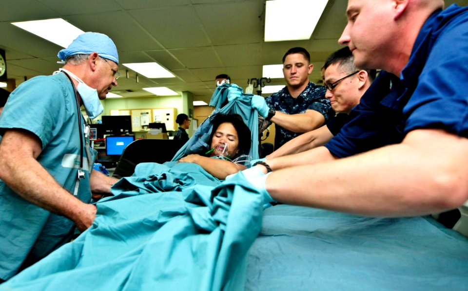 Flickr - Official U.S. Navy Imagery - Service members from the U.S. Navy and Australian army help lift a Filipino women onto a bed in the intensive care unit.