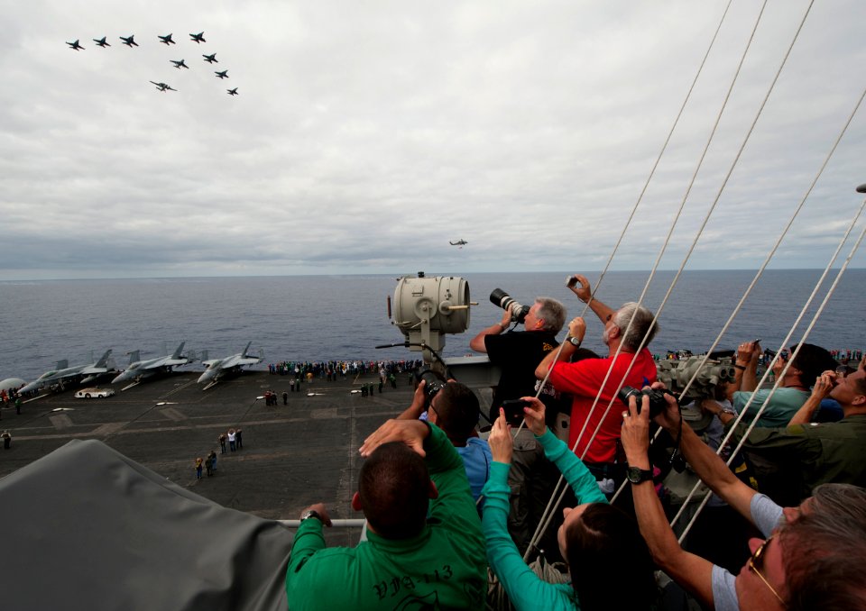 Flickr - Official U.S. Navy Imagery - Tiger cruise participants watch as a formation of aircraft fly by.