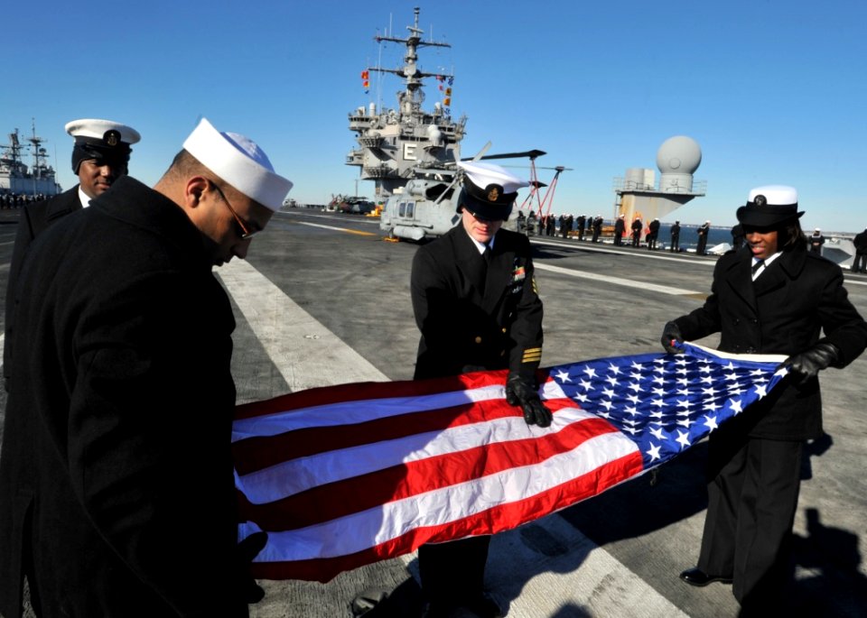 Flickr - Official U.S. Navy Imagery - USS Enterprise Sailors fold flag as ship departs Norfolk on deployment.