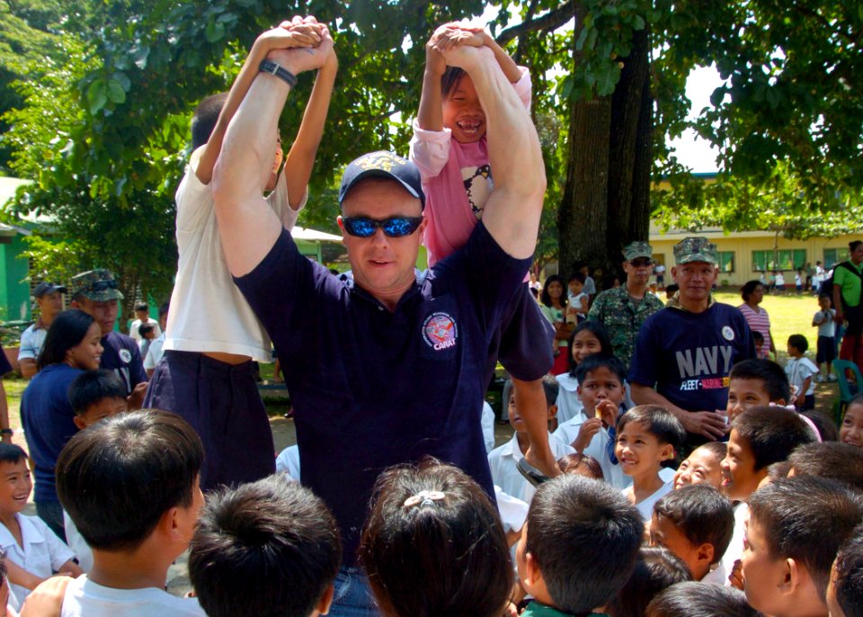 Flickr - Official U.S. Navy Imagery - USS Howard Sailor lifts children at Tagburos Elementary School during a Cooperation Afloat Readiness and Training (CARAT) Philippines 2011 community service project