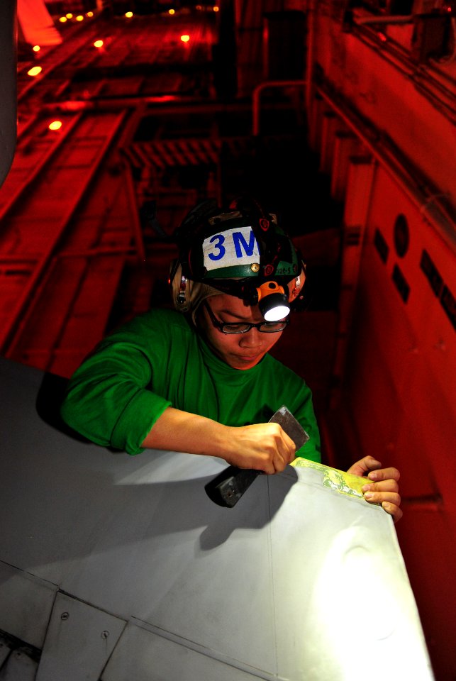 Flickr - Official U.S. Navy Imagery - USS John C. Stennis Sailor removes the leading edge tape off an F-A-18F Hornet wing