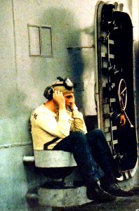Flight deck crewman rests aboard USS Enterprise (CVAN-65) off Vietnam, in April 1966 (428-GX-K-31332)