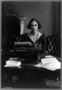 Flora Payne Whitney Miller, three-quarter length portrait, seated at typewriter, facing front LCCN89713565