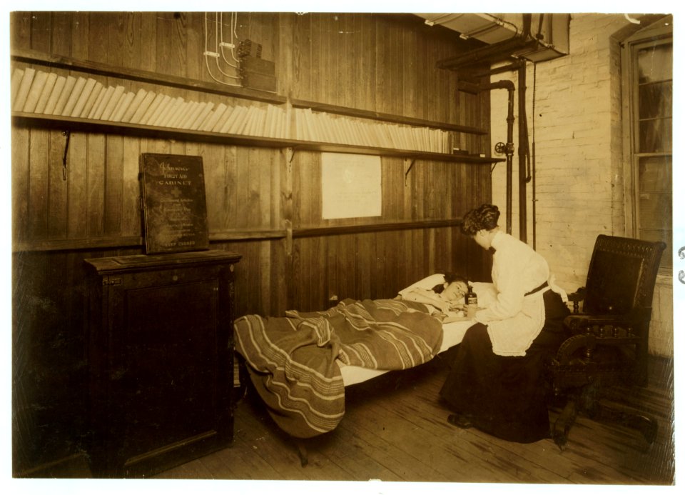 For Child Welfare Exhibit 1912-13.) A patient. A sick worker receiving First Aid, in room set apart for hospital use and library, Brym & Marsh, Pawtucket, R.I Ma(nu)f(acture)rs of electric LOC nclc.02717