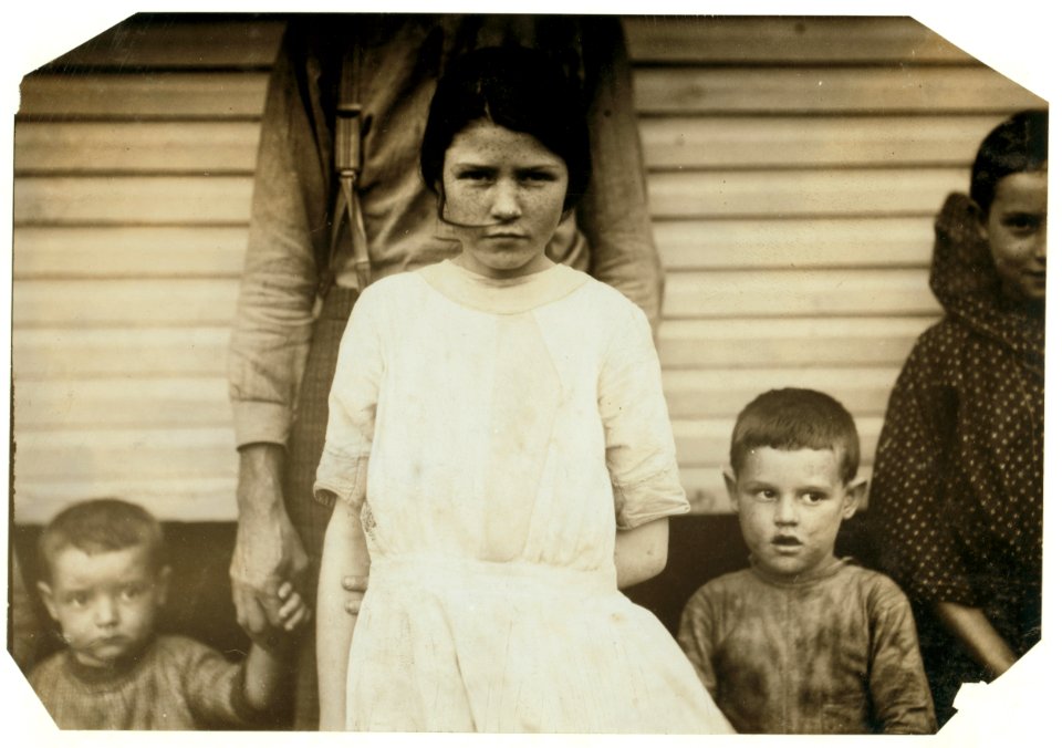 Gracie Clark, 269 A Street (with white dress) has been a spinner in the filling room of Merrimack Mill for three years. Her Life Insurance Policy gives her age thirteen years now, so she LOC nclc.02898