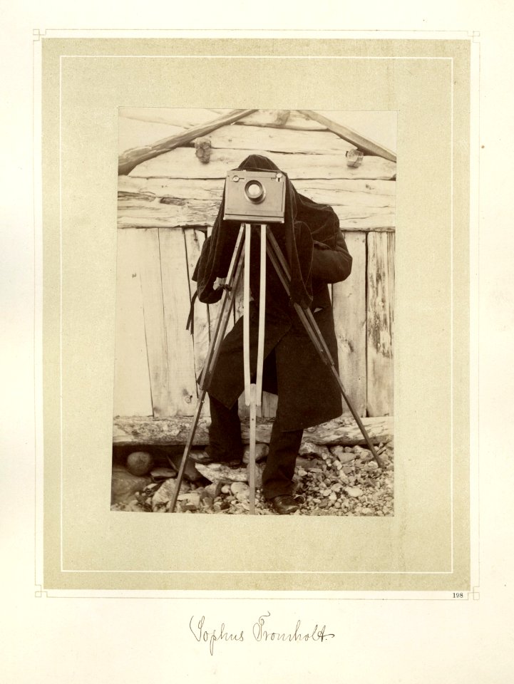 Fotograf med klede over hodet, bak et kamera på stativ - Norsk folkemuseum - NF.15006-001